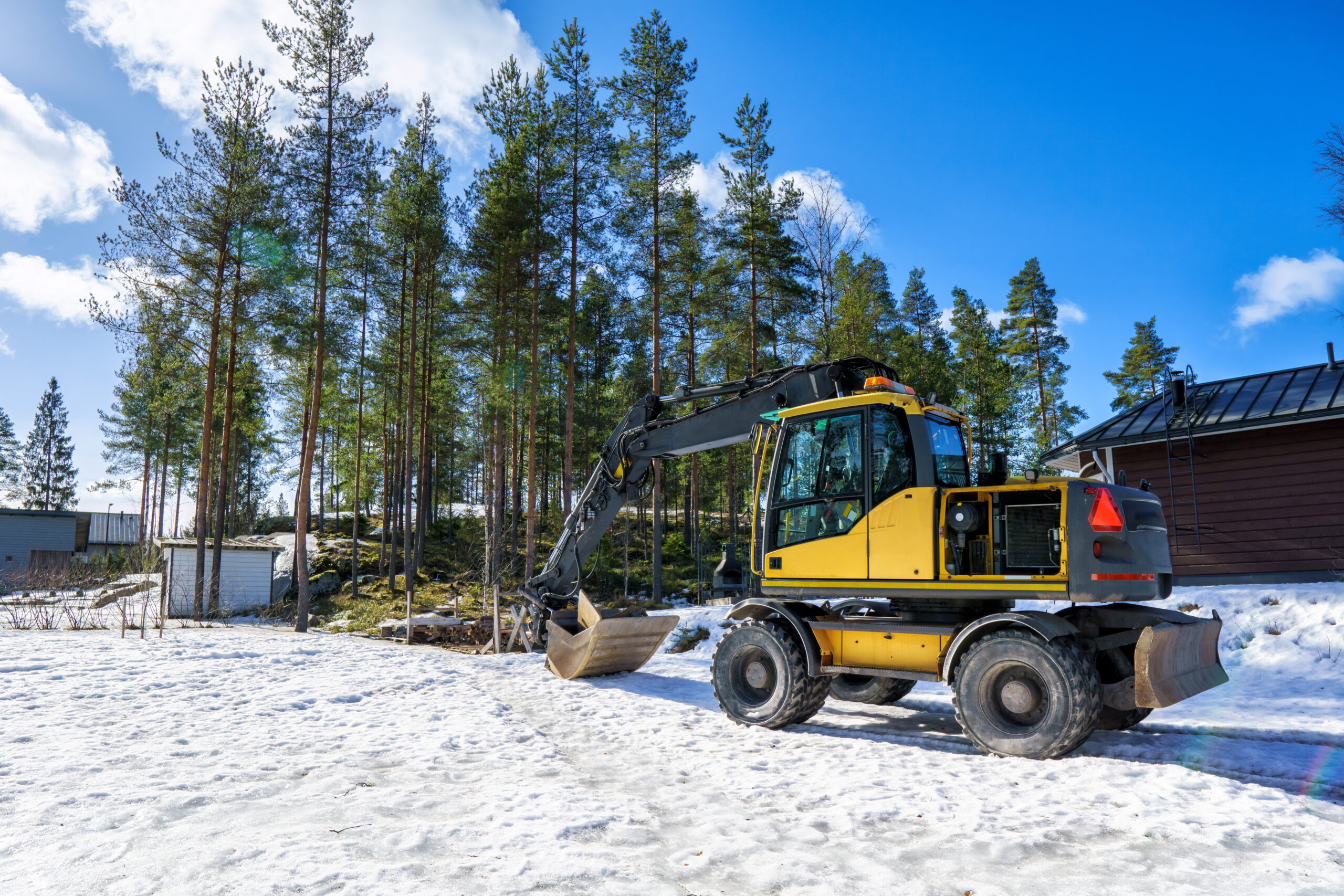 A Yellow Excavator On A Cold Winter Morning. The Start Of A Construction Project In A Winter Landscape.